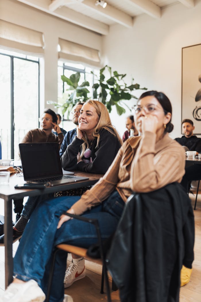 A diverse team engaged in a collaborative meeting inside a modern, naturally lit office.